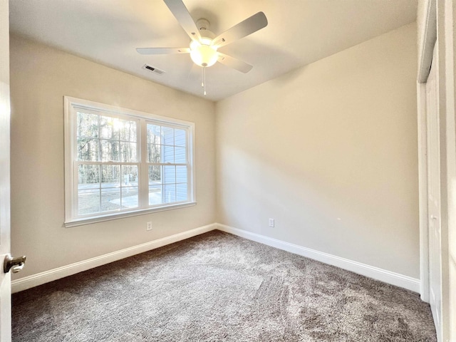 2593 Main St, Loris, SC 29569 - spare room featuring dark colored carpet, baseboards, and a ceiling fan