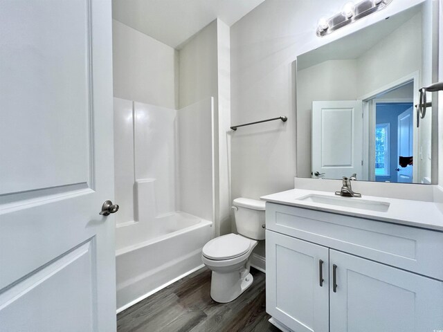 2593 Main St, Loris, SC 29569 - full bath featuring toilet, wood finished floors, vanity, washtub / shower combination, and baseboards