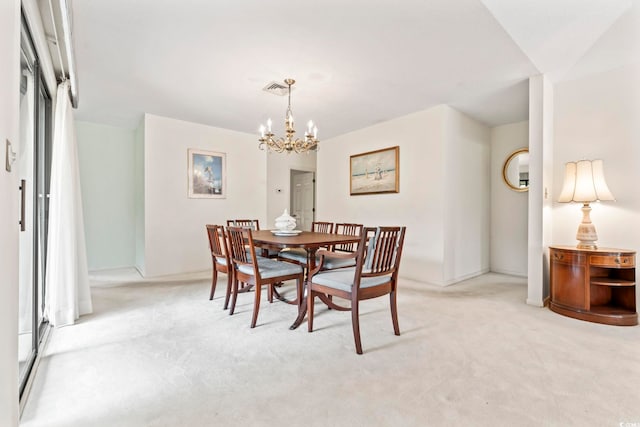 dining area featuring a chandelier, light colored carpet, and baseboards