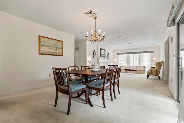 dining space with light carpet, a chandelier, and a tray ceiling