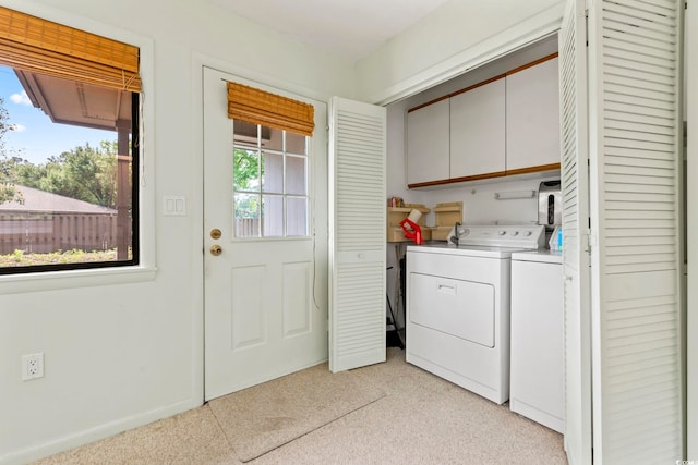 laundry area with cabinet space, separate washer and dryer, and light colored carpet