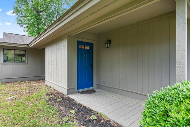 view of exterior entry featuring a shingled roof