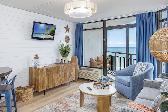 1501 S Ocean Blvd Unit 1250, Myrtle Beach, SC 29577 - living area with wood finished floors, wood walls, a wall unit AC, and a wall of windows