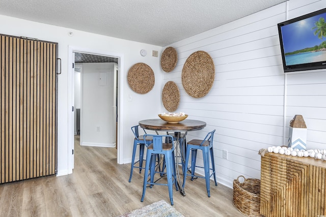 1501 S Ocean Blvd Unit 1250, Myrtle Beach, SC 29577 - dining area with wood finished floors, a textured ceiling, baseboards, and wooden walls