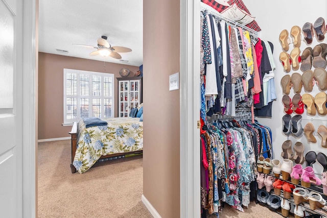 spacious closet featuring ceiling fan and carpet
