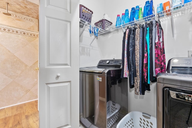 laundry room with washing machine and clothes dryer and wood finished floors