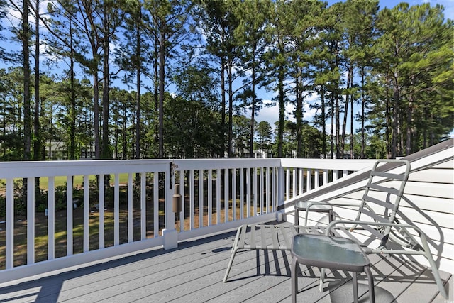 wooden deck with view of wooded area