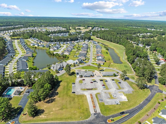 aerial overview of property's location featuring a forest, a nearby body of water, and nearby suburban area