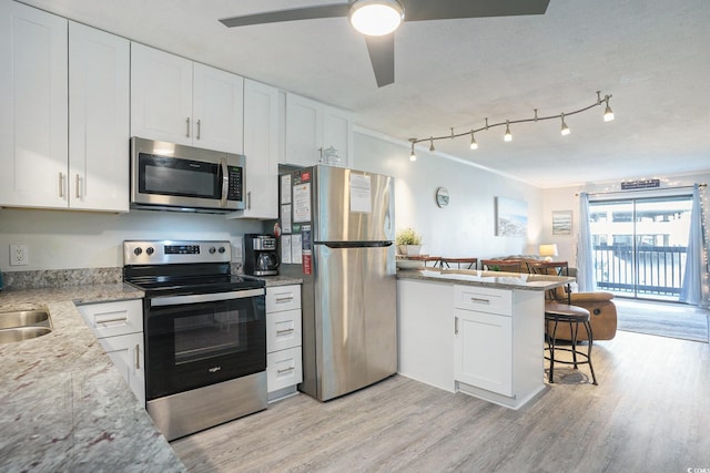 6000 N Ocean Blvd Unit 133, North Myrtle Beach, SC 29582 - kitchen with stainless steel appliances, a peninsula, light wood-style floors, and white cabinetry
