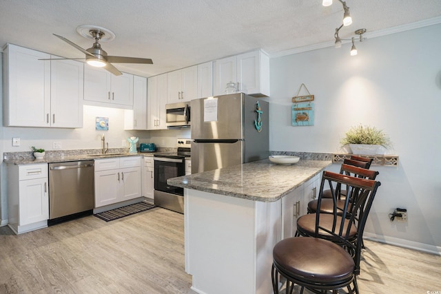 6000 N Ocean Blvd Unit 133, North Myrtle Beach, SC 29582 - kitchen featuring appliances with stainless steel finishes, a sink, a breakfast bar, a peninsula, and light wood-style floors
