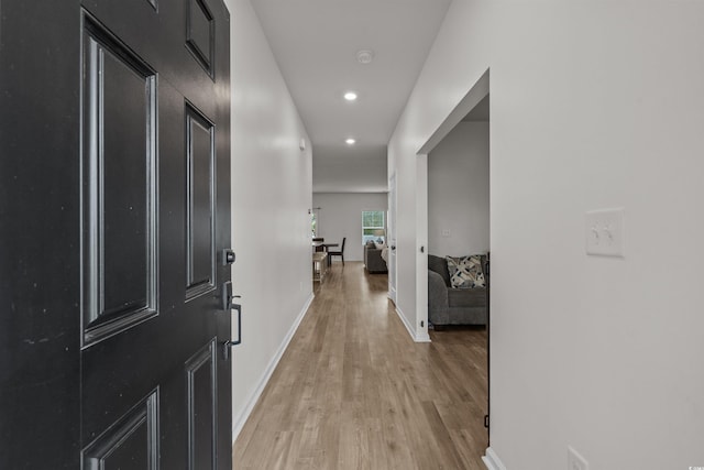 hallway with light wood-type flooring, recessed lighting, and baseboards