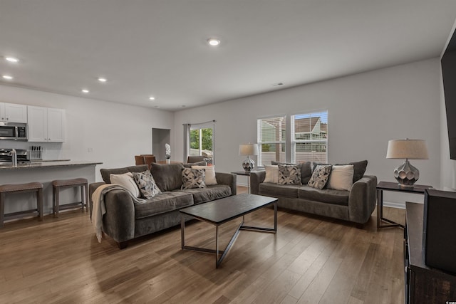 living area featuring wood finished floors and recessed lighting