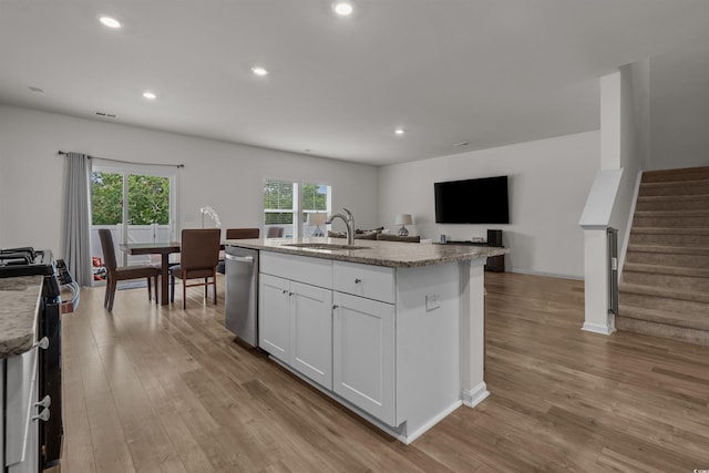 kitchen featuring a sink, stainless steel appliances, wood finished floors, white cabinetry, and recessed lighting