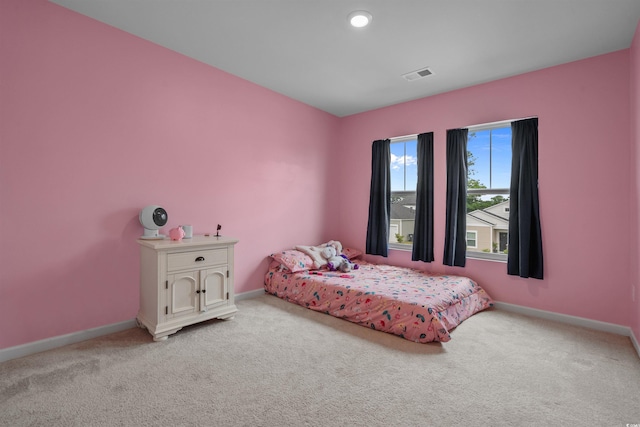 bedroom featuring light carpet and baseboards