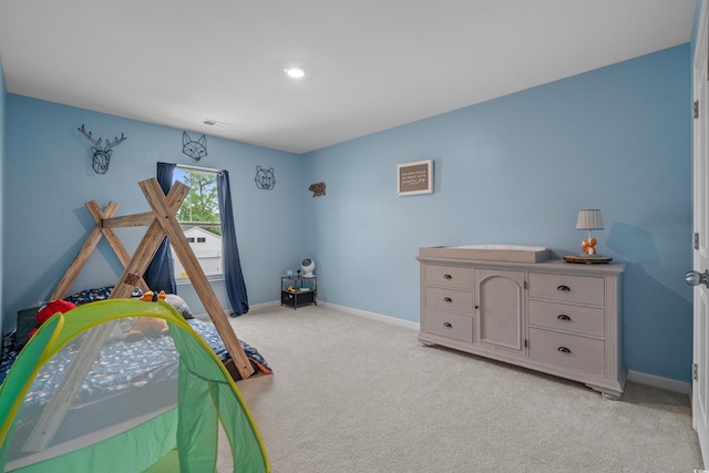 bedroom featuring light carpet and baseboards