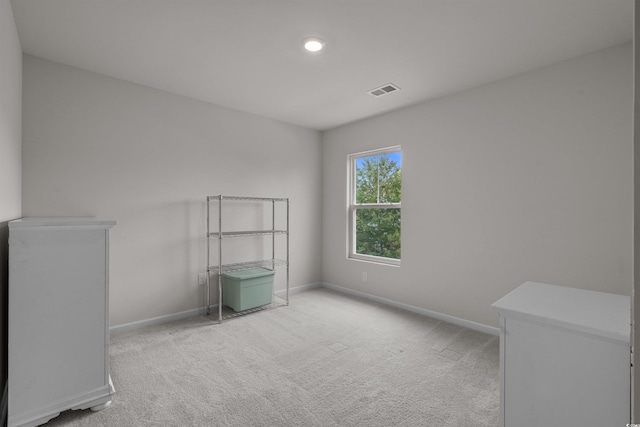spare room with light colored carpet and baseboards