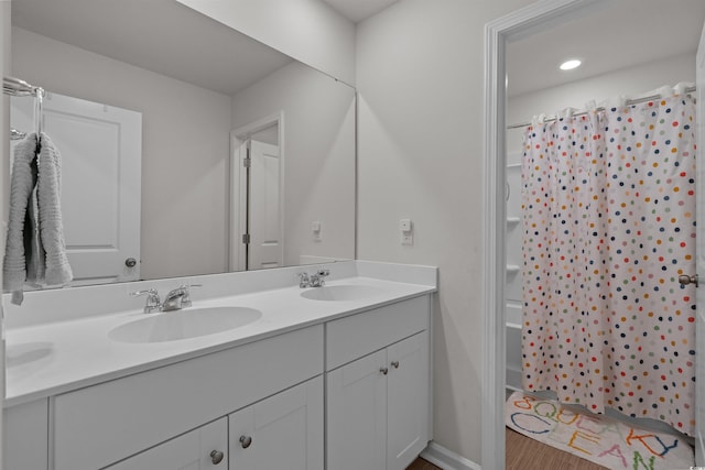bathroom with double vanity, wood finished floors, and a shower with shower curtain