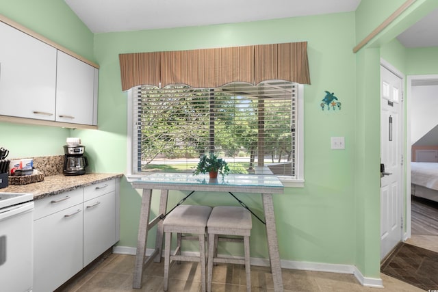 400 Melrose Pl Unit 14E, Myrtle Beach, SC 29572 - kitchen featuring electric range, healthy amount of natural light, white cabinetry, and light stone counters