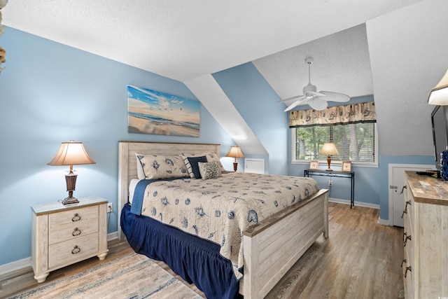 400 Melrose Pl Unit 14E, Myrtle Beach, SC 29572 - bedroom with wood finished floors, baseboards, a textured ceiling, lofted ceiling, and a ceiling fan