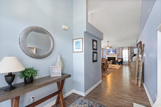 corridor with wood finished floors and baseboards