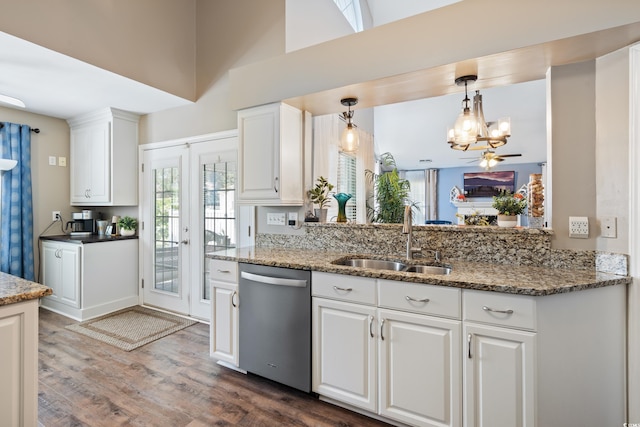 kitchen with stainless steel dishwasher, a sink, a chandelier, dark wood finished floors, and white cabinetry