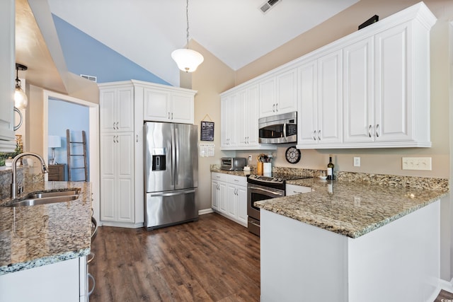 kitchen with stainless steel appliances, a sink, a peninsula, light stone counters, and white cabinetry