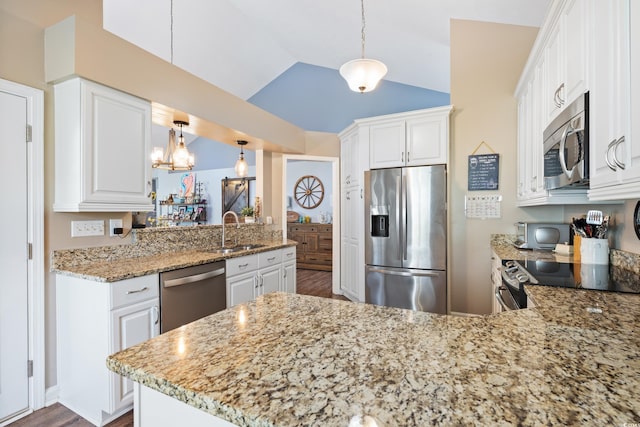 kitchen with stainless steel appliances, a peninsula, a sink, dark wood finished floors, and vaulted ceiling