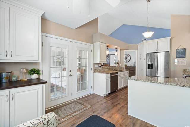 kitchen with stainless steel appliances, white cabinets, dark wood finished floors, and lofted ceiling