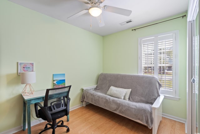 office space featuring baseboards, light wood-type flooring, and a ceiling fan