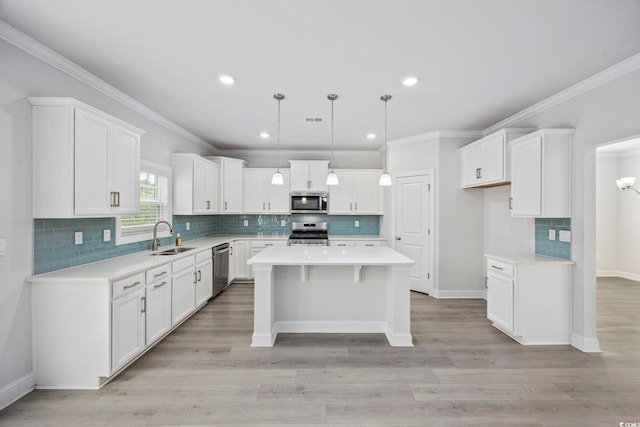1303 Bermuda Grass Dr, Myrtle Beach, SC 29579 - kitchen with appliances with stainless steel finishes, a sink, a kitchen island, white cabinets, and ornamental molding