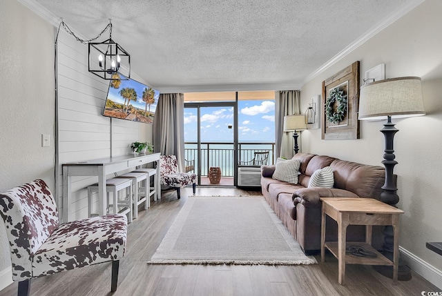 6900 N Ocean Blvd Unit 1437, Myrtle Beach, SC 29572 - living area with a textured ceiling, wood finished floors, ornamental molding, a wall of windows, and a chandelier