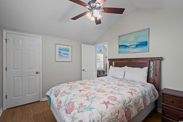 bedroom featuring vaulted ceiling, wood finished floors, a ceiling fan, and baseboards
