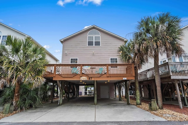back of property featuring a carport, driveway, and a deck
