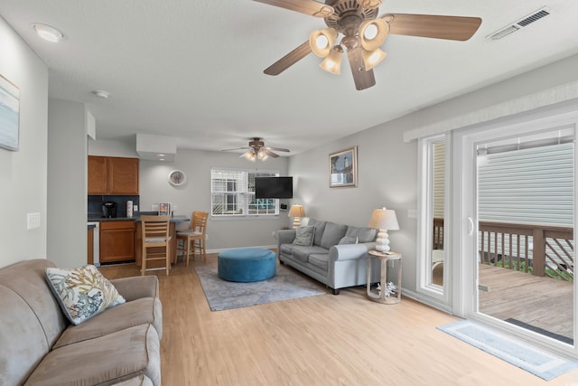 living area featuring ceiling fan, wood finished floors, and baseboards