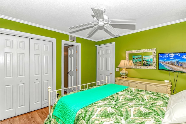 bedroom with a textured ceiling, wood finished floors, ceiling fan, and crown molding