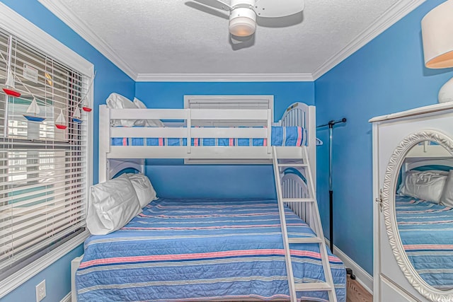 bedroom with a textured ceiling, baseboards, ornamental molding, ceiling fan, and wood finished floors