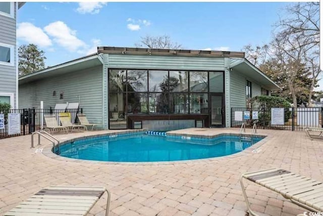 community pool with fence and a patio area