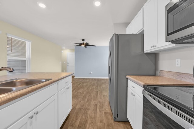 478 Samara Dr, Longs, SC 29568 - kitchen with appliances with stainless steel finishes, a sink, white cabinets, light wood finished floors, and a ceiling fan