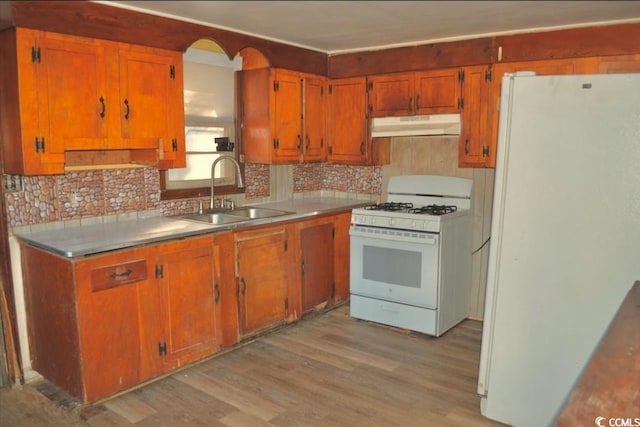 414 E Wine St, Mullins, SC 29574 - kitchen with white appliances, under cabinet range hood, a sink, light wood-style flooring, and brown cabinetry