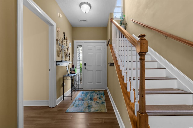 entrance foyer featuring wood finished floors, baseboards, and stairway