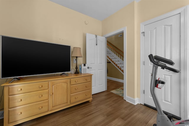 workout area with dark wood-type flooring and baseboards
