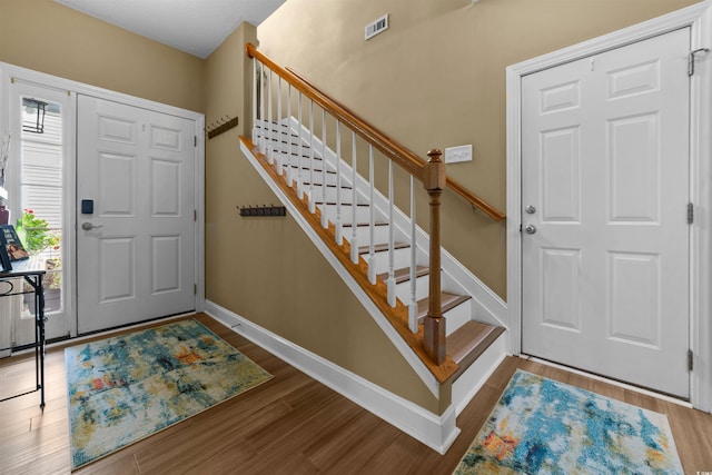 entrance foyer featuring wood finished floors, stairs, and baseboards