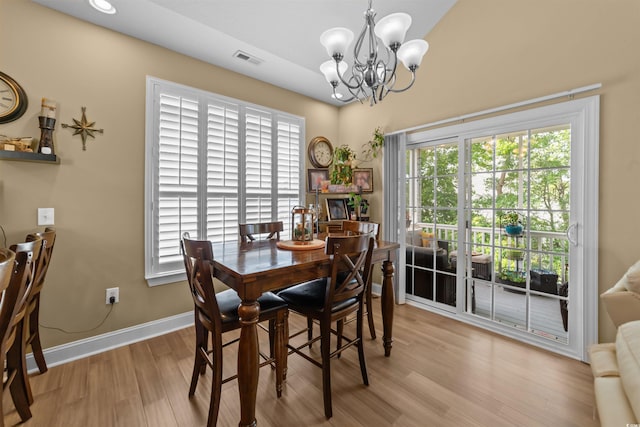 dining room with a chandelier, wood finished floors, and baseboards