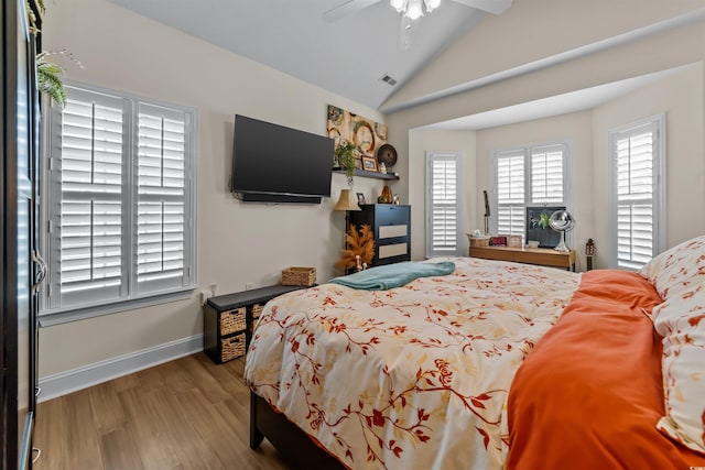bedroom with vaulted ceiling, wood finished floors, baseboards, and a ceiling fan