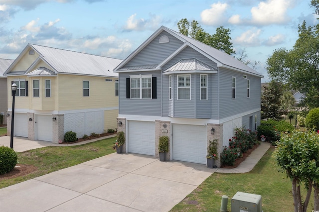 view of front of property featuring an attached garage, brick siding, metal roof, concrete driveway, and a front yard