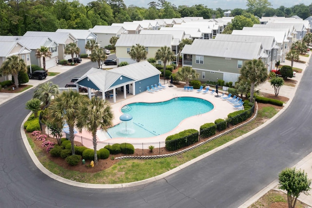 community pool featuring fence, a residential view, and a patio
