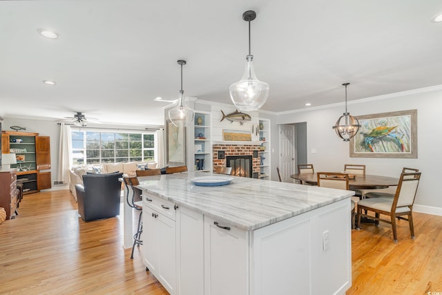2604 S Bay St, Georgetown, SC 29440 - kitchen featuring open floor plan, a fireplace, white cabinetry, light wood-style floors, and recessed lighting