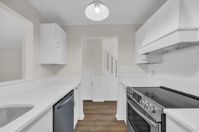 kitchen with appliances with stainless steel finishes, custom exhaust hood, white cabinetry, and dark wood-style floors