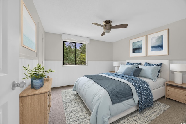 bedroom featuring carpet floors, wainscoting, and a ceiling fan