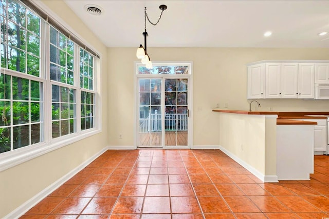 154 Windsor Cir SW, Ocean Isle Beach, NC 28469 - kitchen featuring light tile patterned floors, white microwave, white cabinets, decorative light fixtures, and recessed lighting